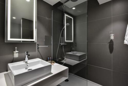 瓦夫尔Novotel Wavre Brussels East的浴室设有白色水槽和镜子