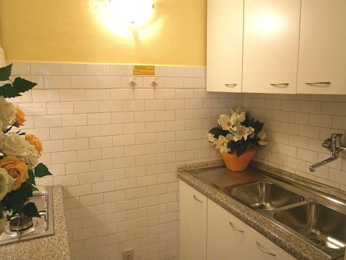 比比翁Ida的厨房设有水槽和白色瓷砖墙壁。