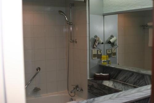 顺义北京国都大饭店的带淋浴、浴缸和镜子的浴室