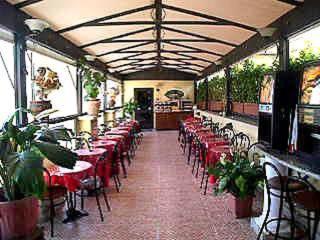 罗马那蒂兹美洲酒店的一间设有红色桌椅的用餐室