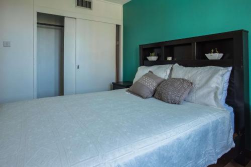 欧丘里欧Emerald One Bedroom Suite At Turtle Towers的卧室配有一张带两个枕头的大白色床