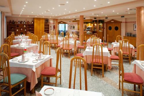 Cabia卡维亚里奥酒店的一间设有白色桌椅的用餐室和一间餐厅