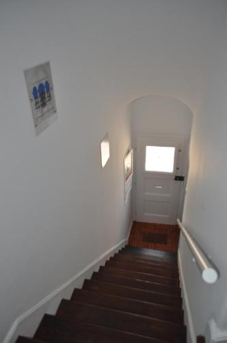 埃武拉A Casa do Mestre的走廊设有楼梯、白色门和窗户