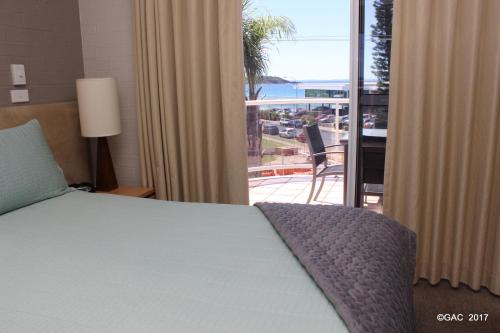 莫里莫科莫里莫科湾公寓式酒店的一间卧室设有一张床,享有阳台的景色