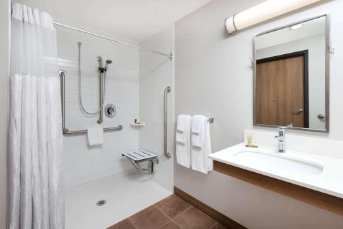 萨德伯里温德姆萨德伯里微型套房酒店的白色的浴室设有水槽和淋浴。