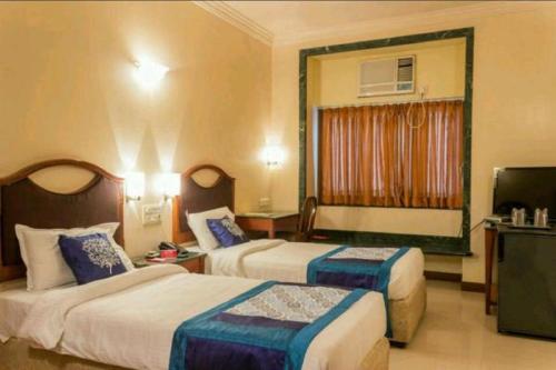 孟买Strand Hotel, Colaba的酒店客房设有两张床和电视。