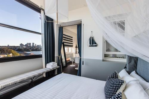 悉尼帕里萨德酒店的一间卧室设有一张床和一个大窗户