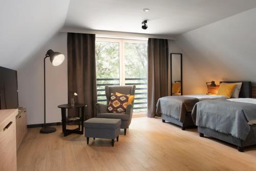 绿山城Apartamenty Centrum Park的一间卧室设有两张床、一把椅子和一个窗户。