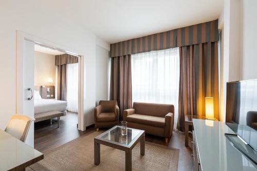 拉科鲁尼亚Eurostars Atlántico的酒店客房设有一个带电视的起居区。