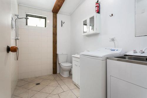 TamaherePickering Barn Stay的白色的浴室设有水槽和卫生间。