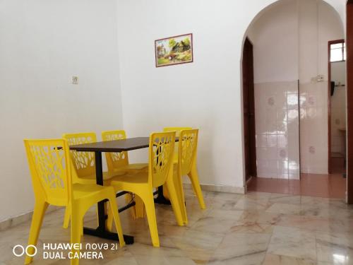 太平Taiping Guest House的用餐室配有黄色椅子和桌子
