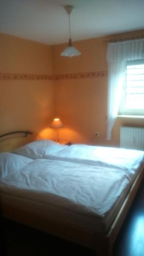 弗里茨拉尔Ferienwohnung St. Wigbert的卧室配有白色的床和窗户。