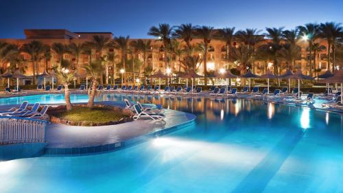 赫尔格达吉夫腾阿祖尔度假酒店的一个带椅子和棕榈树的度假村游泳池