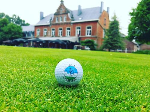 Sart-Dames-AvelinesGîtes du Golf的坐在房子前面的草地上的高尔夫球