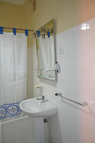 圣多美Hotel Central的浴室配有盥洗盆、镜子和浴缸