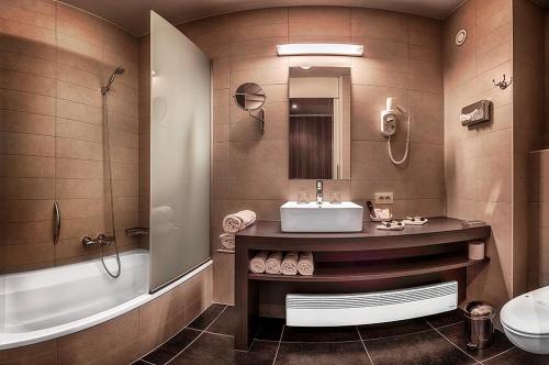 马尔德海姆克雷斯尔酒店的浴室配有盥洗盆、卫生间和浴缸。