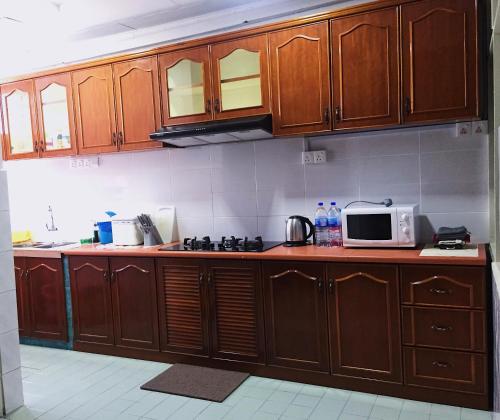 乔治市Bayan Baru Homestay @ Taman Sri Nibong的一间带木制橱柜和微波炉的厨房
