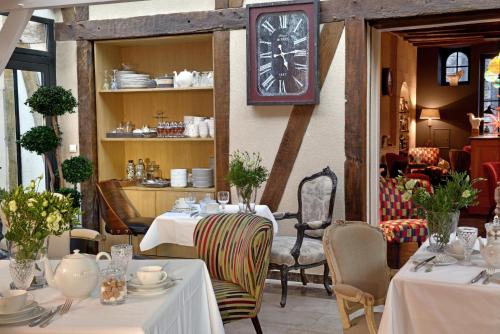 索米尔圣皮埃尔酒店的墙上有桌子和时钟的餐厅