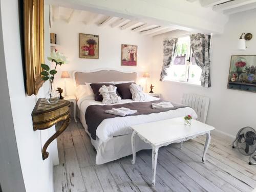 Berville-sur-MerLa Romance et la Romanesque的卧室配有白色的床和桌子