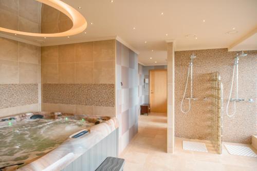 陶格夫匹尔斯拉果拉公园酒店的大型浴室设有浴缸和淋浴。