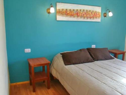 蒂尔卡拉Rinconcito en Tilcara的一间卧室设有一张床和蓝色的墙壁