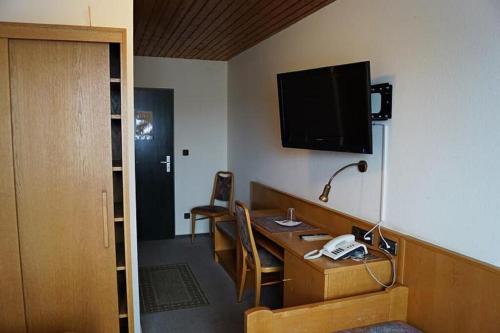 RötzHotel-Landgasthof Henghuber的客房设有带电话和电视的书桌。