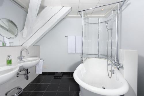 布格多夫斯塔德豪斯酒店的一间带水槽、浴缸和卫生间的浴室