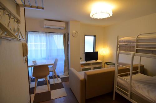 别府Comfort CUBE PHOENIX Beppu (やよいビル)的小房间设有书桌和双层床