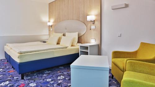 默费尔登-瓦尔多夫祖姆洛恩酒店的一间卧室配有一张床、一张沙发和一把椅子