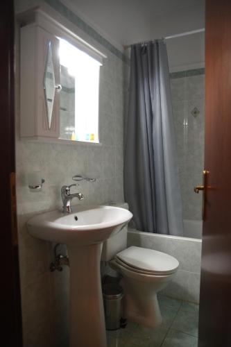 波尔塔里亚Archontiko Klitsa的一间带水槽和卫生间的浴室以及窗户。