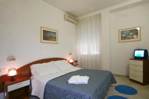 里米尼伊吉拉索里住宅酒店的一间卧室配有一张床,上面有两条毛巾