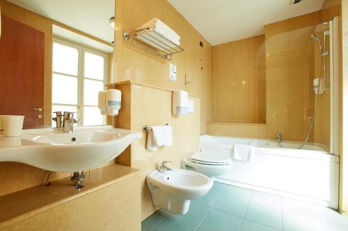 都灵Liberty Hotel的浴室配有盥洗盆、卫生间和浴缸。