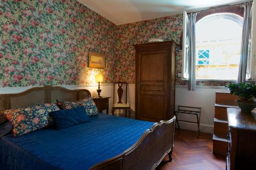 罗马阿科德托洛美宾馆的一间卧室配有蓝色的床和花卉壁纸