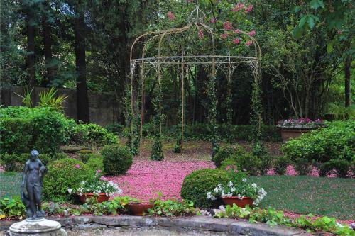 阿雷佐La Striscia Wine Resort的花园中,有雕像,中间有鲜花