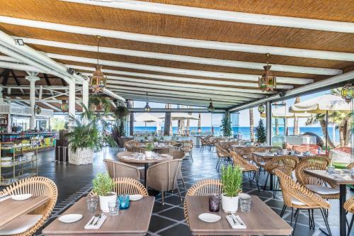 Estepona埃斯特波纳巴伊亚海滩公寓的餐厅设有木制天花板和桌椅