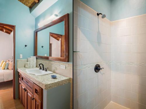 IguanaTown House 9的浴室配有盥洗盆和带镜子的淋浴