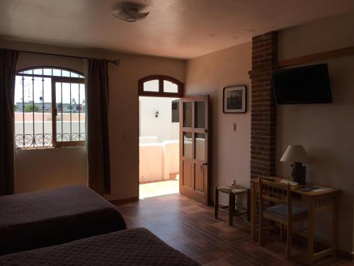 瓦曼特拉Hostal el Dulce Nombre的一间卧室配有一张床、一张书桌和一个窗户。