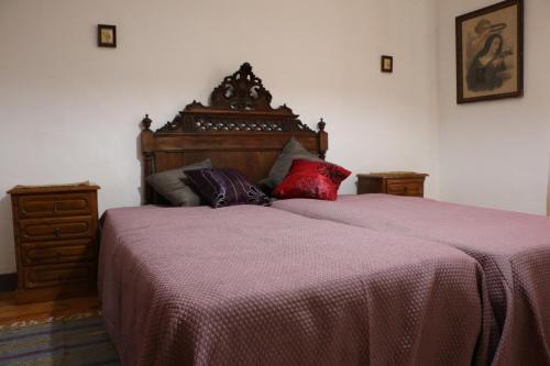 萨布罗萨Solar dos Avós的一间卧室配有一张大床和木制床头板