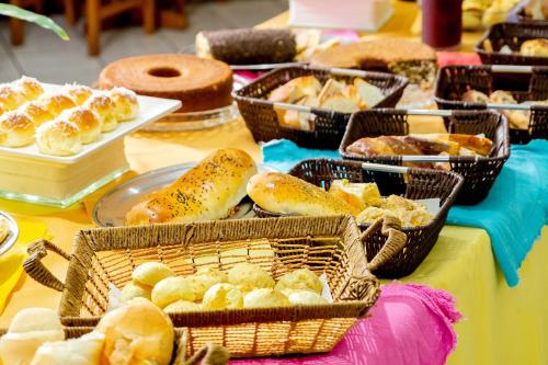 阿蒂巴亚Itapetinga Hotel的一张桌子,上面有面包和糕点篮子