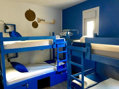 托莱多托莱多绿洲背包客旅馆的蓝色的客房设有三张双层床。