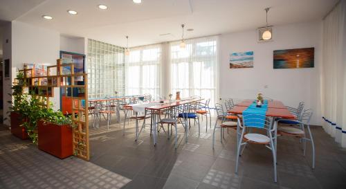 波尔托罗Hostel Soline的用餐室设有桌椅和窗户。