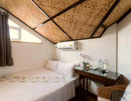 曼谷曼考拉别墅旅馆的一间小卧室,配有一张床和一张桌子