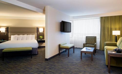 萨斯卡通萨斯卡通会议中心酒店的酒店客房设有床和客厅。
