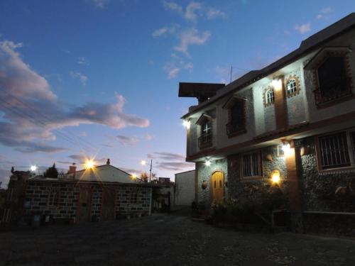 TambilloHostal Ñuca Huasi的夜晚,房子的一侧有灯