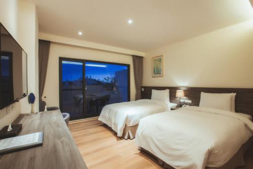 Fang-liao枋客文旅 的酒店客房设有两张床和电视。