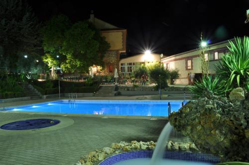 HorcheLa Fuensanta Hostal-Rural的夜间在房子前面的游泳池