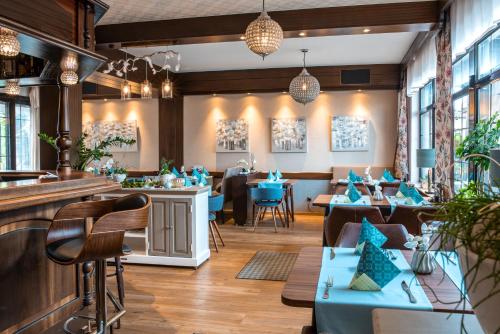 Newel维森格兰餐厅-乡村旅馆的一间设有蓝色桌椅的餐厅和一间酒吧