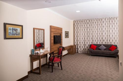 阿拉木图欧亚大酒店 的酒店客房配有书桌和沙发。
