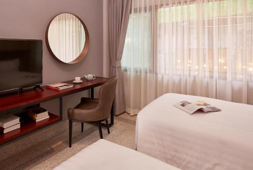曼谷布拉纱里W22酒店【SHA Plus+】的酒店客房配有一张床、一张书桌和一台电视。