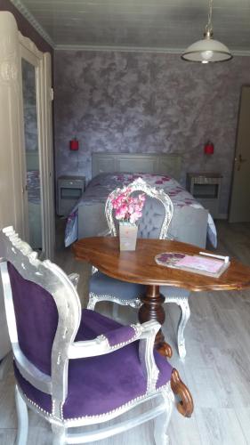 MamirolleAu Doubs Cocon Fleuri的配有桌椅和床的房间